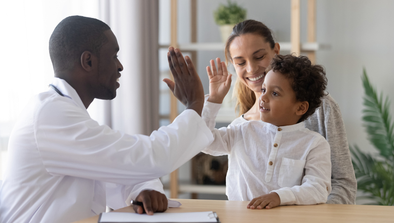 Child and parent talking with doctor